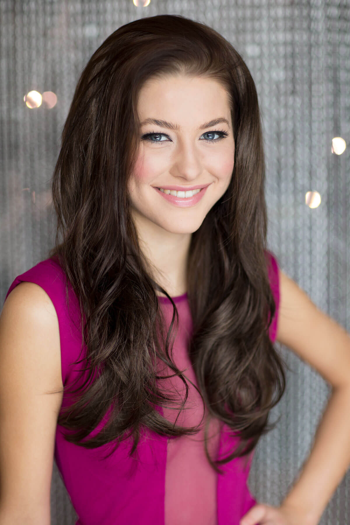 Woman with long brown hair wearing a pink dress against a sparkly background. Brown half wig hairpiece (3/4 wig), gently layered: Briar chestnut brown 8 