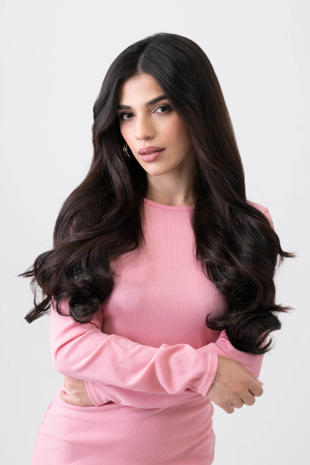 Woman wearing a pink dress against a light gray background