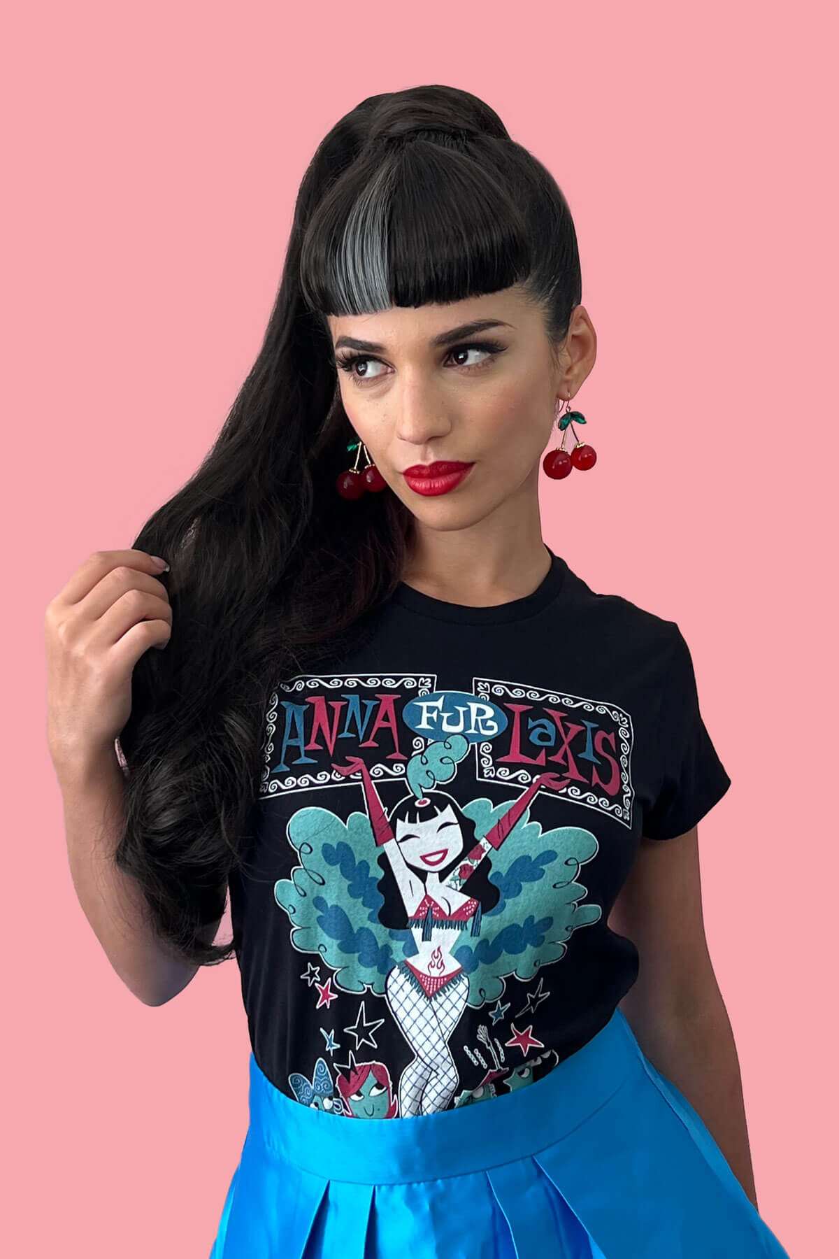 Woman wearing a black t-shirt with a colorful graphic design on a pink background