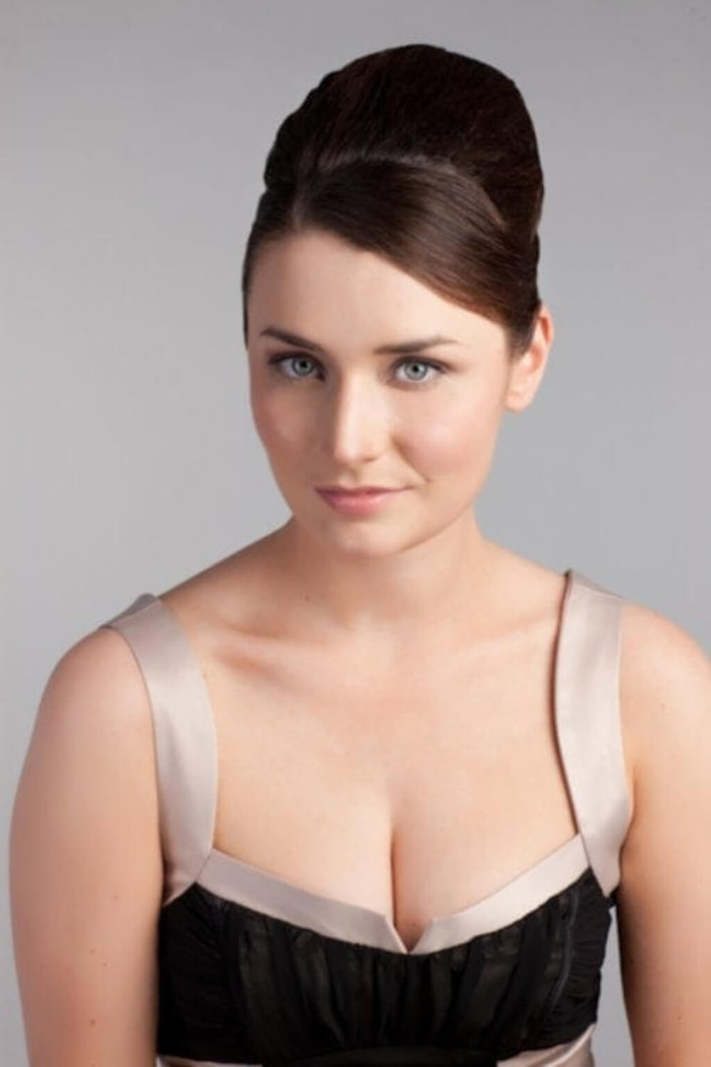 A woman with her hair styled in a beehive, wearing a black bustier-style top with beige satin straps and trim. Height Booster Hairpiece Volume and Height Booster Hairpiece, chestnut  brown 8