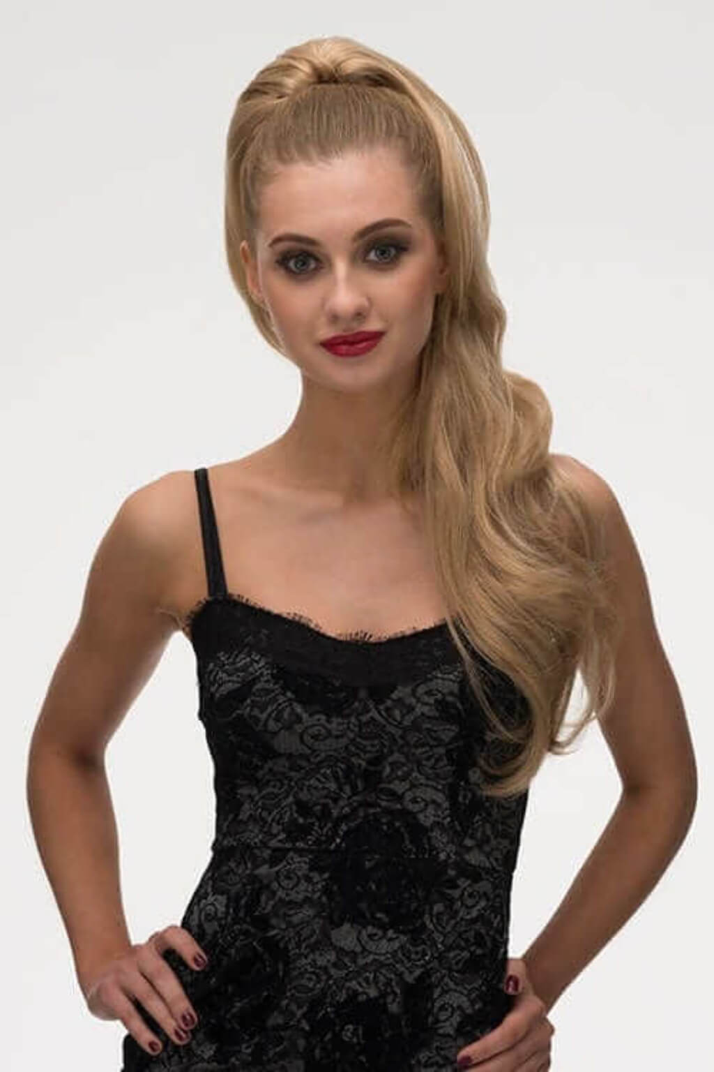 Woman wearing a black lace dress against a white background. Clip-in ponytail hairpiece extension: Olivia