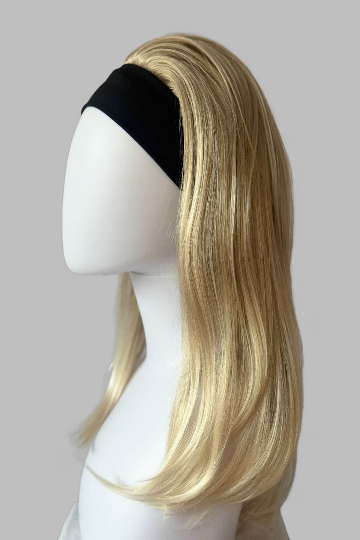 A close-up of a headband blonde half wig hairpiece showing the texture of the hair. Headband half wig hairpiece, long and straight: Isla Blonde 613T24
