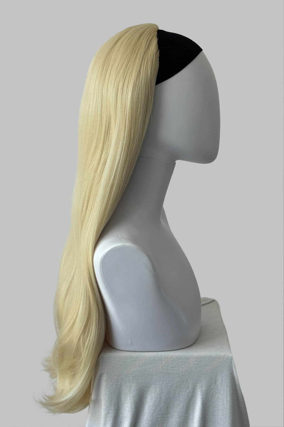 Blonde wig on a mannequin head with a black band against a plain background. Kate - Heat Styleable Extra Long, Gentle Wave Half Wig  blonde 613