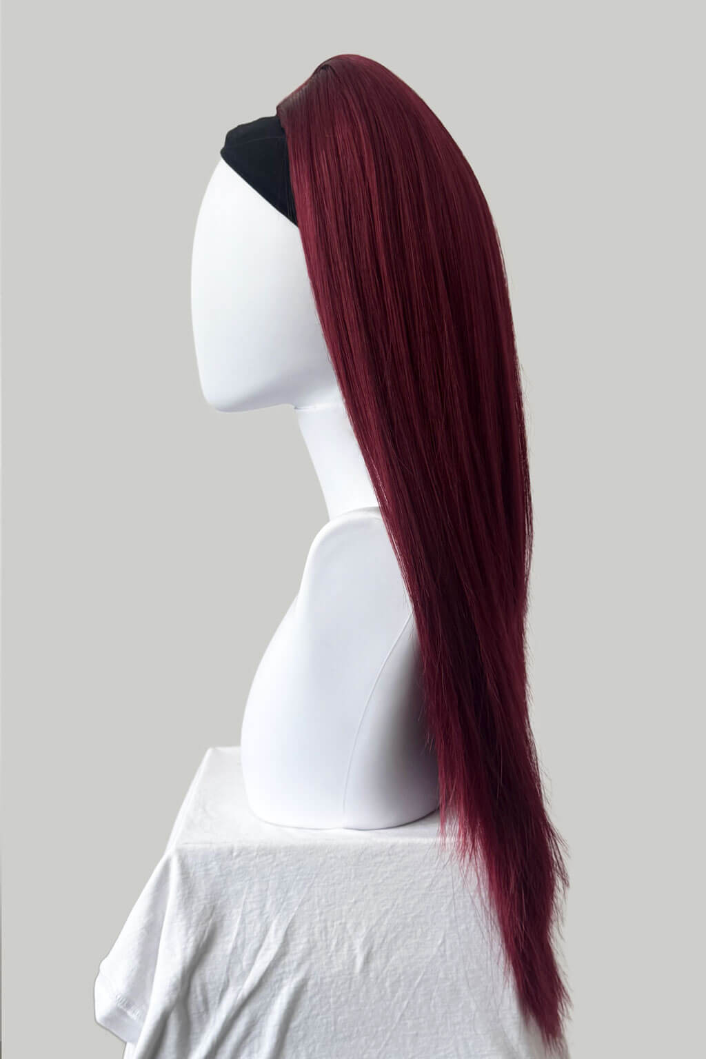 Red wig on a mannequin head against a plain background. 1960s style hair, high crown long straight half wig: Andrea cherry red 39