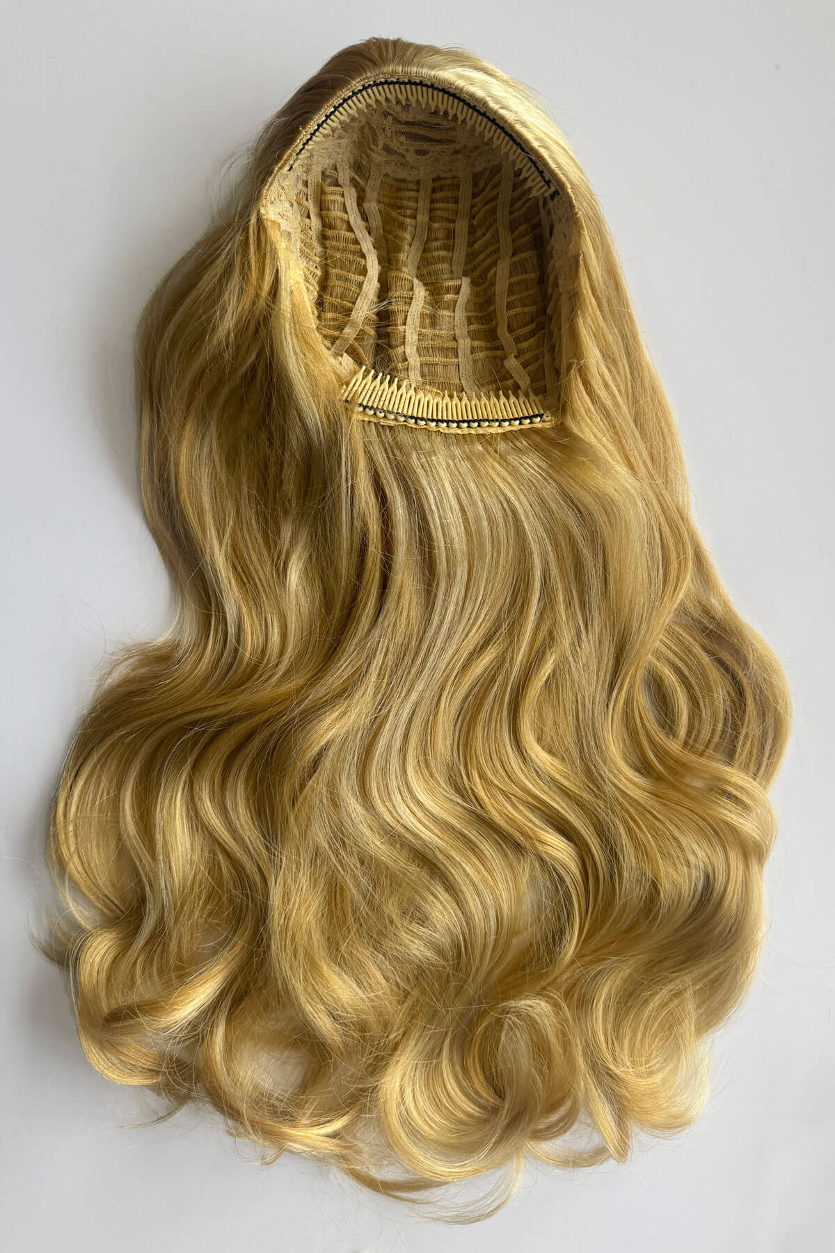 Long wavy blonde half wig, displayed against a plain background. Corrine - Bouncy Blowout style with Volume Booster Half Wig warm blonde 24BH613
