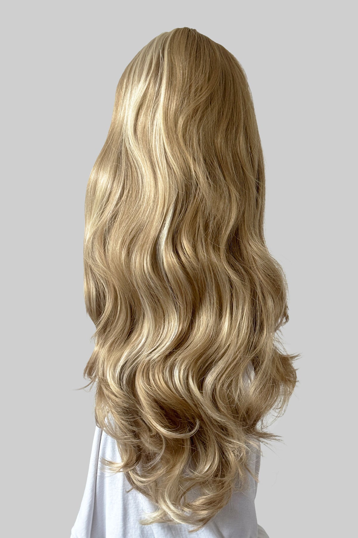Long, wavy blonde wig shown from the back on a model against a grey background. Corrine - Bouncy Blowout style with Volume Booster Half Wig blonde 24H613