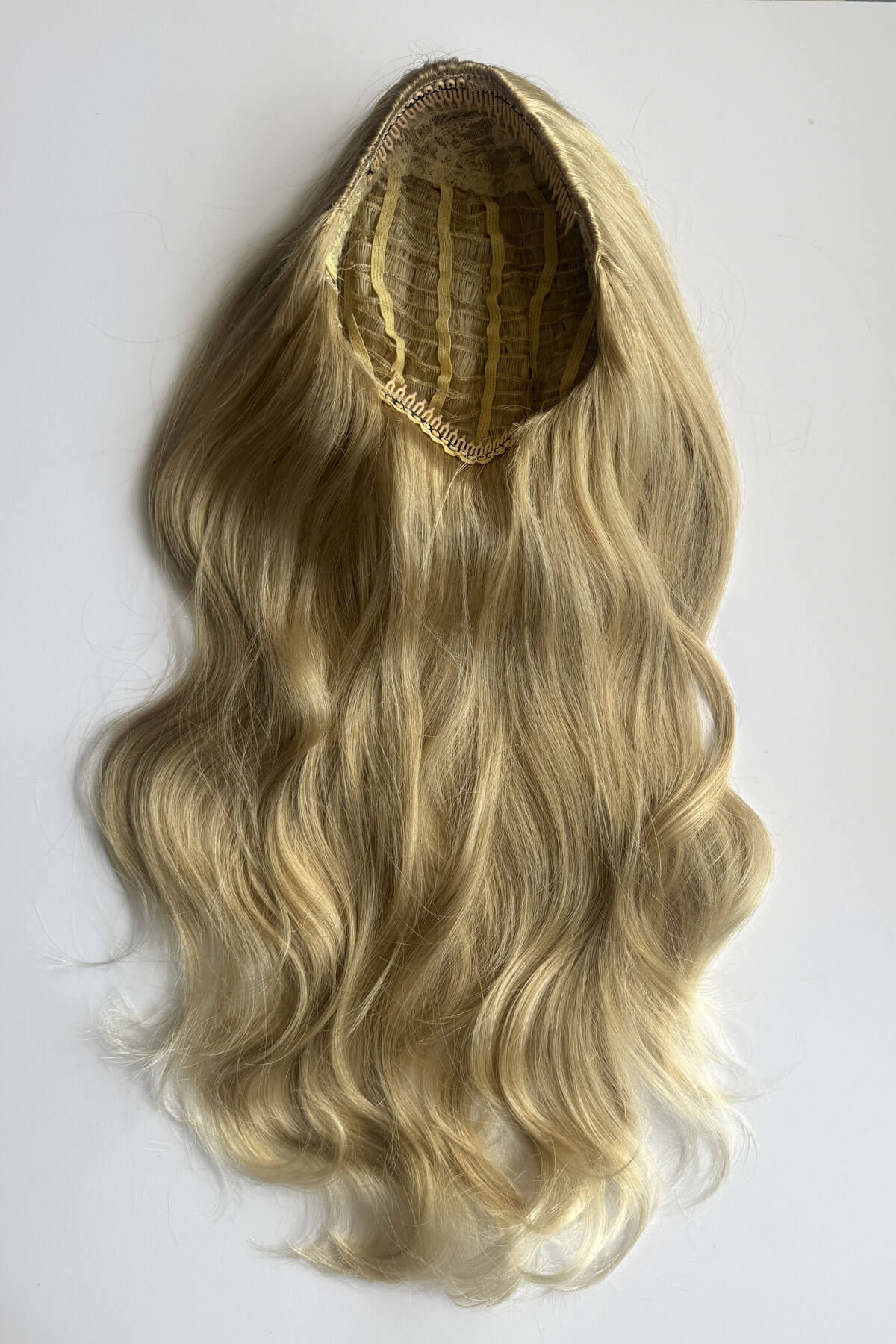 A long wavy blonde half wig with a natural-looking lace top, displayed against a plain white background. Corrine - Bouncy Blowout style with Volume Booster Half Wig blonde 613T24