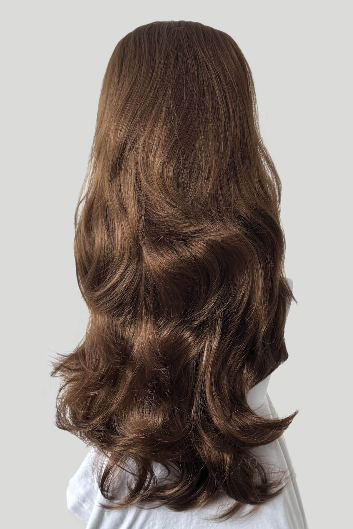 Long, wavy brown hair extension on a plain background. High crown long, layered half wig and volume ring: Helena light brown 12