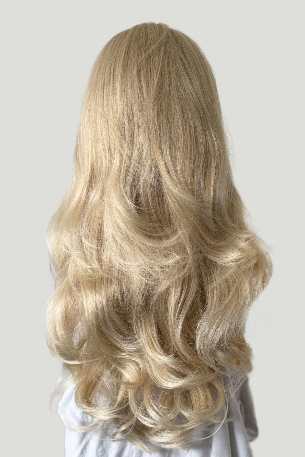 Blonde wig with wavy hair on a white background. Blonde half wig hairpiece (3/4 wig), loose curls: Suki blonde 613T24
