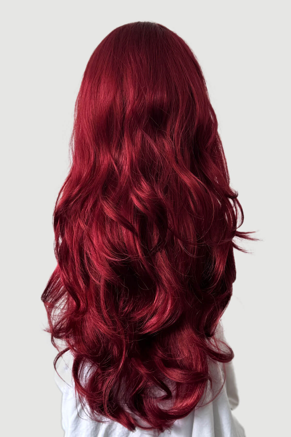 Red hair styled in loose waves on a plain background. Red half wig (3/4 hairpiece) with long waves: Sasha wine red and copper red 350-39