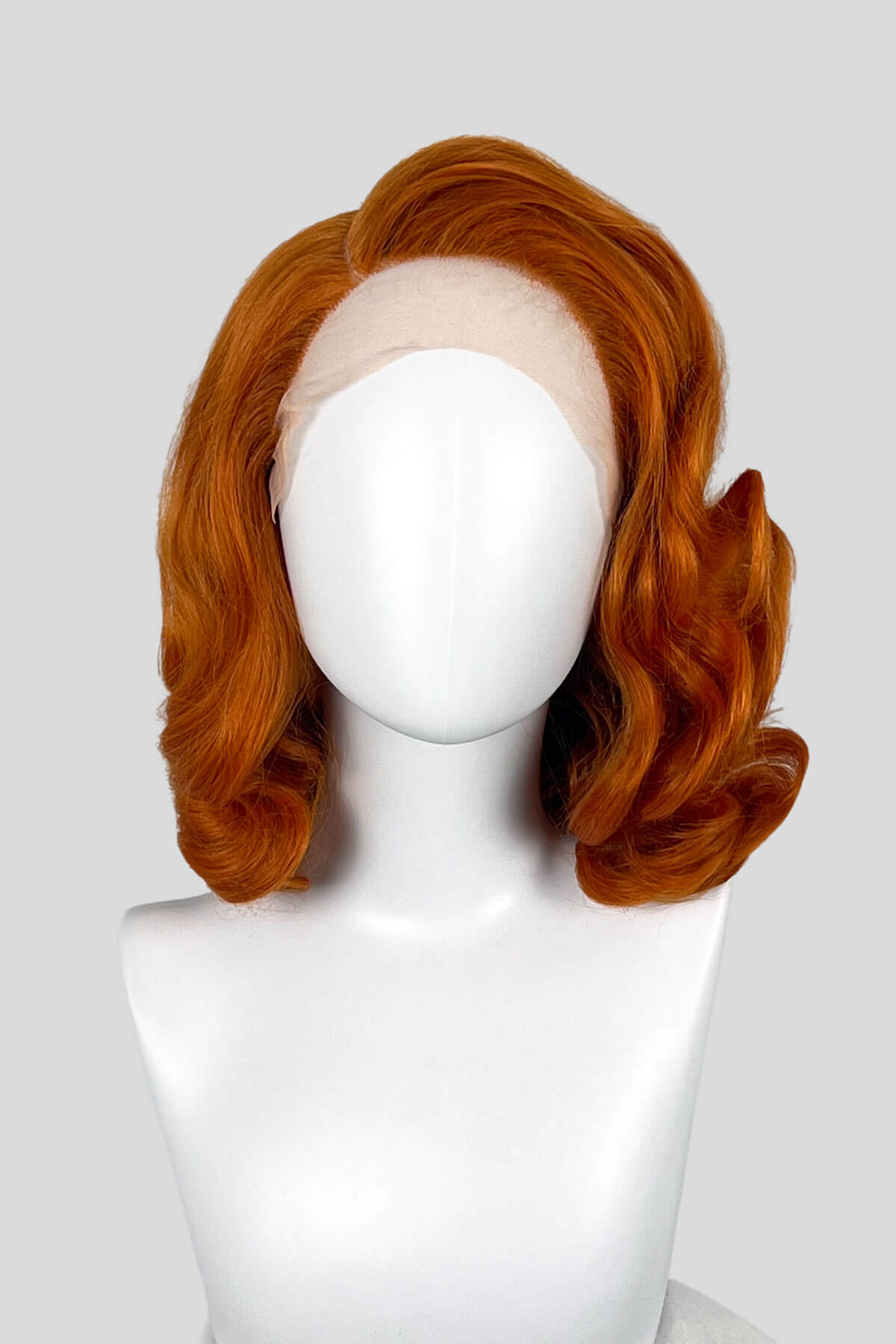 Reddish-brown wig on a white mannequin head against a light gray background. Ginger lacefront wig, pinup/vintage style, mid length with finger waves: Flora 