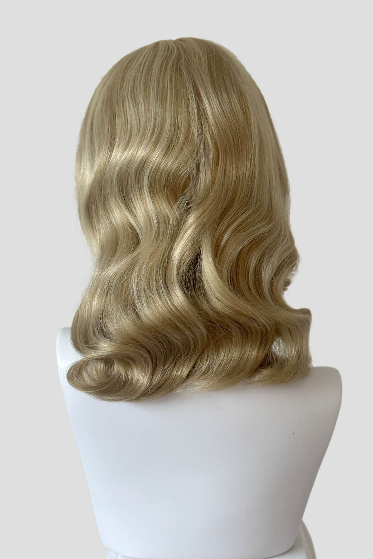 Blonde wig on a mannequin head against a white background. Blonde pinup wig with long finger waves and a short fringe: Cora Blonde 24H613