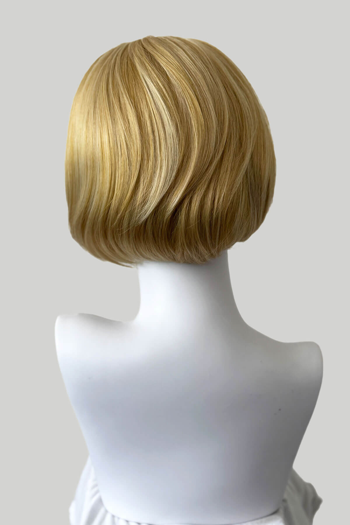 Blonde wig on a mannequin head against a white background.  Bob half wig hairpiece, Flexihair: Amelie honey blonde 24BH613
