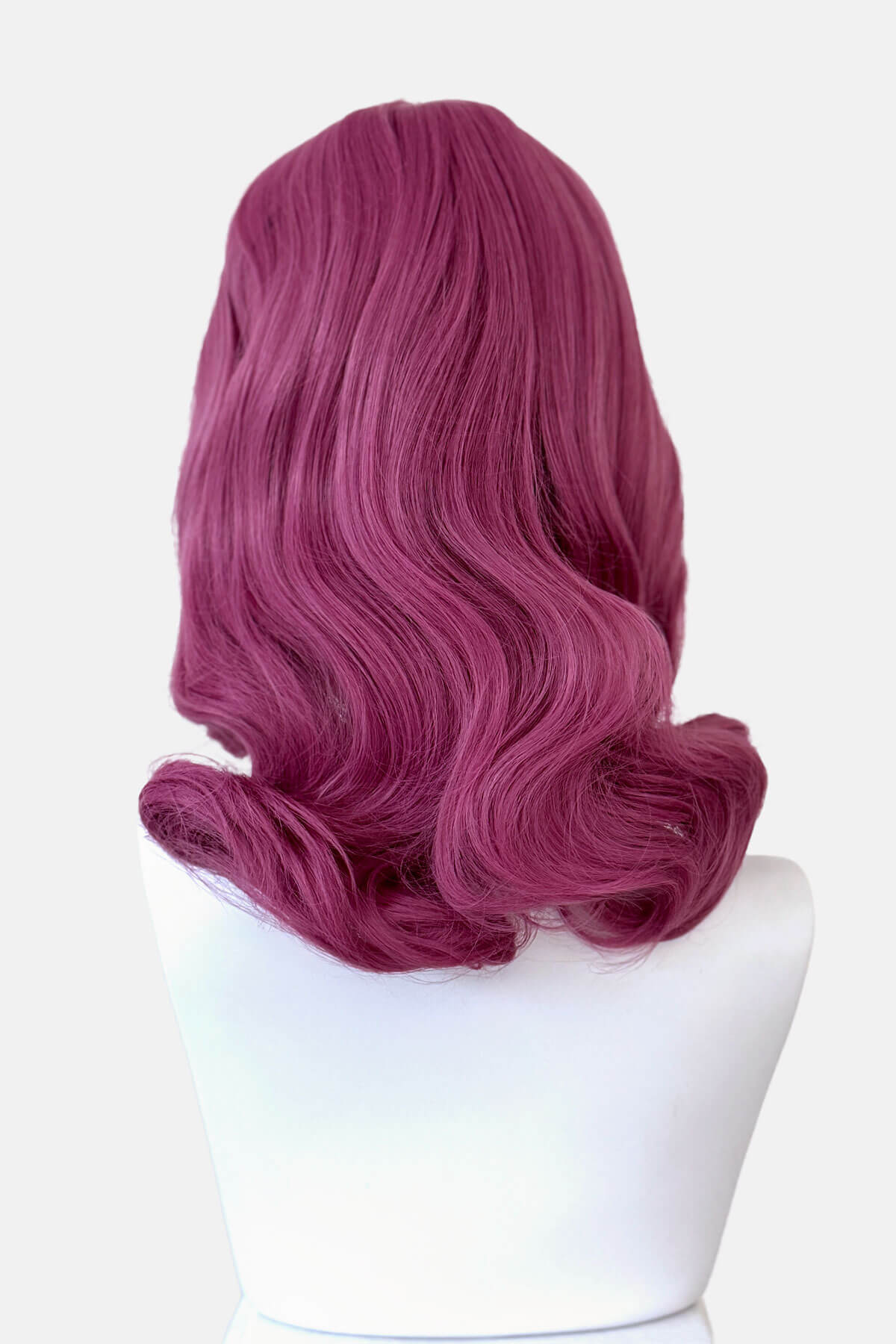 Purple wig on a white mannequin head against a white background. Pink pinup style wig, with finger waves and a short fringe, 1950s style: Stevie 2520J