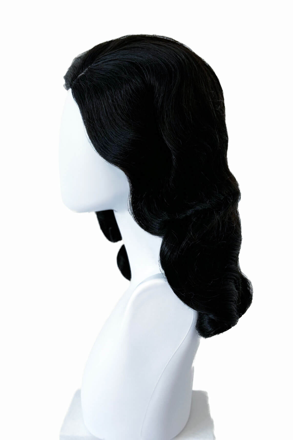 Black wig on a white mannequin head against a white background. Black 1940s style wig with long marcel waves: Vivienne