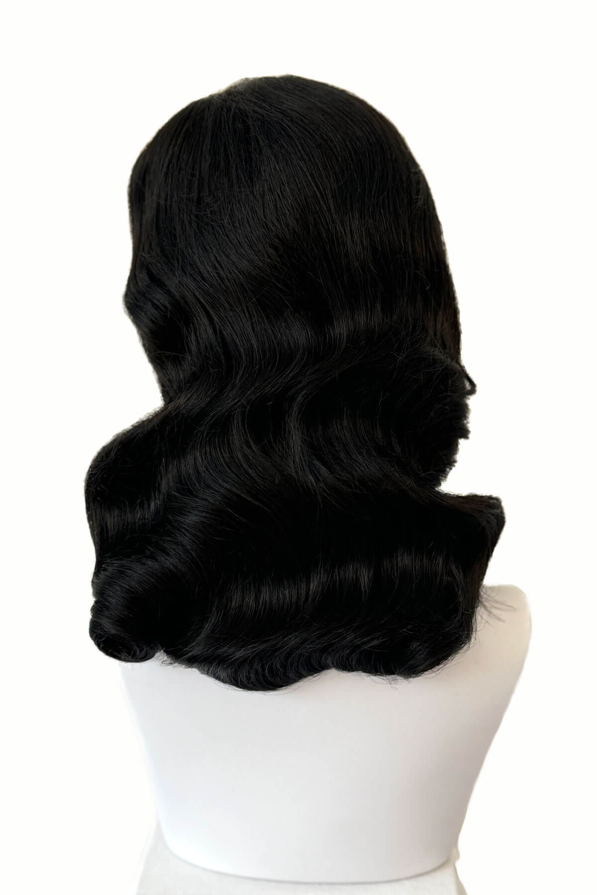 Black wig styled in an elegant updo on a white mannequin head. Black 1940s style wig with long marcel waves: Vivienne