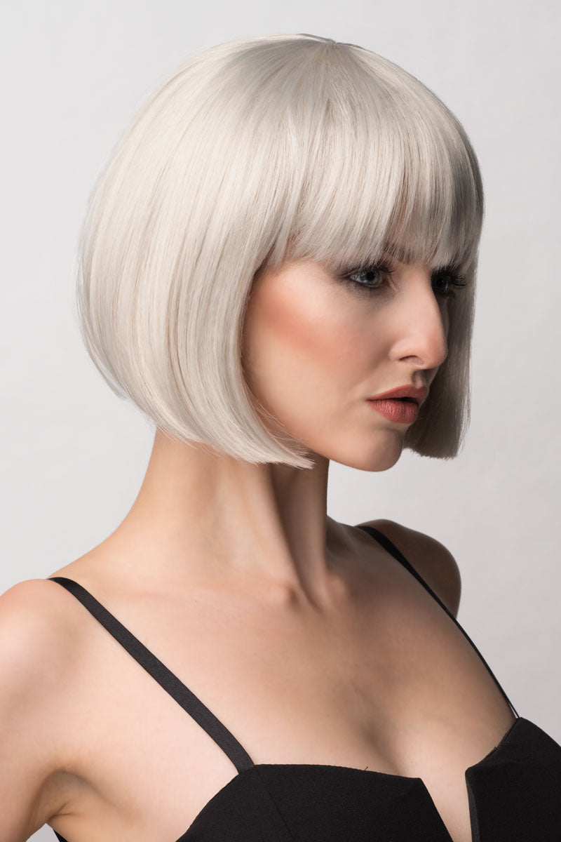 A woman wearing a satin-grey/silver bob wig with a fringe, styled to fall gently to the chin. Satin-grey/silver bob wig, short and chic: Celeste