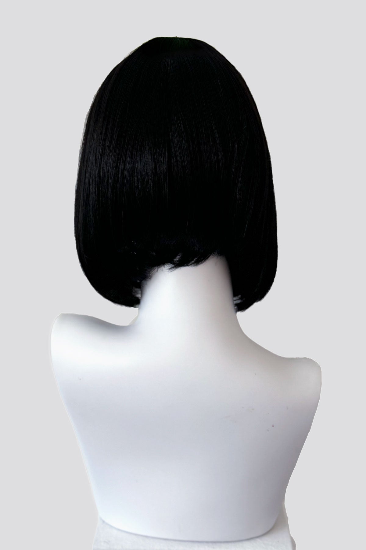 Black bob wig on a white mannequin head against a white background. Black inverted bob wig: Chloe