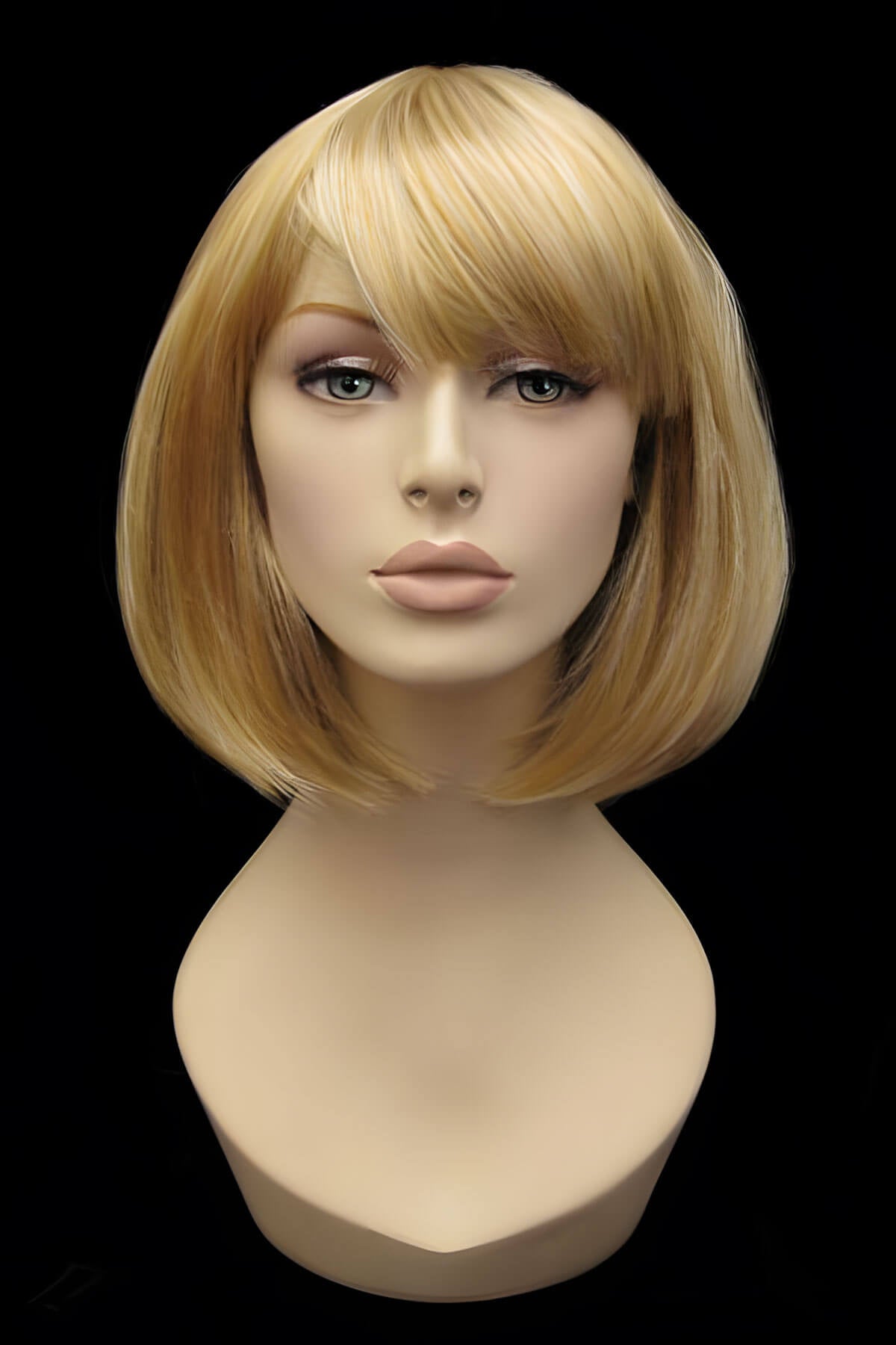 Blonde wig on a mannequin head against a black background.  Blonde inverted bob wig: Rhiannon honey blonde 24BH613