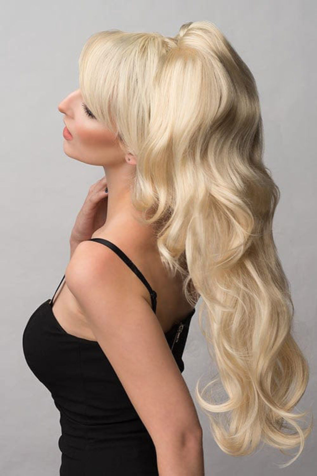 A woman wearing a black dress and a double volume hairpiece extension with gentle waves.
